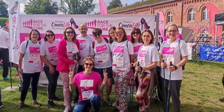 Powiększ grafikę: Nauczycielki Topolówki w strojach startowych stoją na tle banneru Race for the Cure.