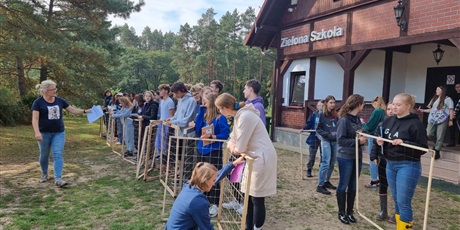 Powiększ grafikę: Zdjęcie uczniów z siatkami do pomiarów populacji przed budynkiem Zielonej Szkoły.