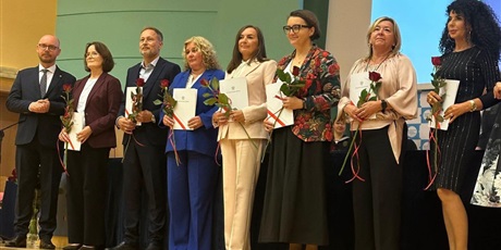 Powiększ grafikę: Laureaci nagrody Kuratora Oświaty stoją na scenie. Trzymają dyplomy i kwiaty.